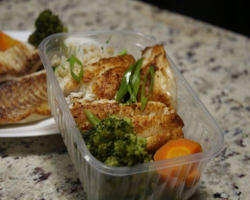 A freshly prepared balanced meal with grilled fish and green vegetables ordered at a clean modern Singapore hawker stall